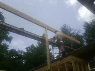 Carpenter setting a ridge beam over a new addition frame — Ice Dam Removal by Roofing Brothers in Pine Grove