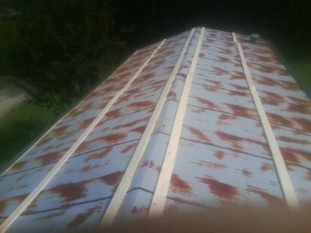Rusted metal roof panels with new wood purlins before replacement — Storm Damage Roof Repair in Pine Grove by Roofing Brothers
