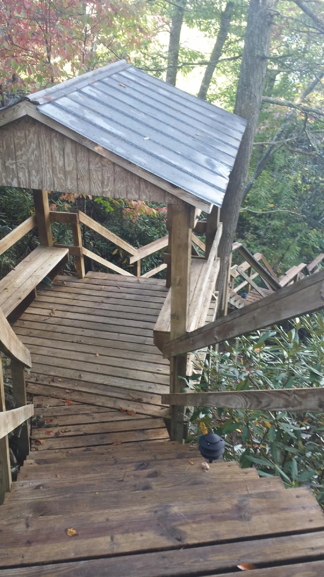 Metal roofed shelter over wooden steps on a wooded walkway — Skylight Repair & Installation work by our crew in Pine Grove