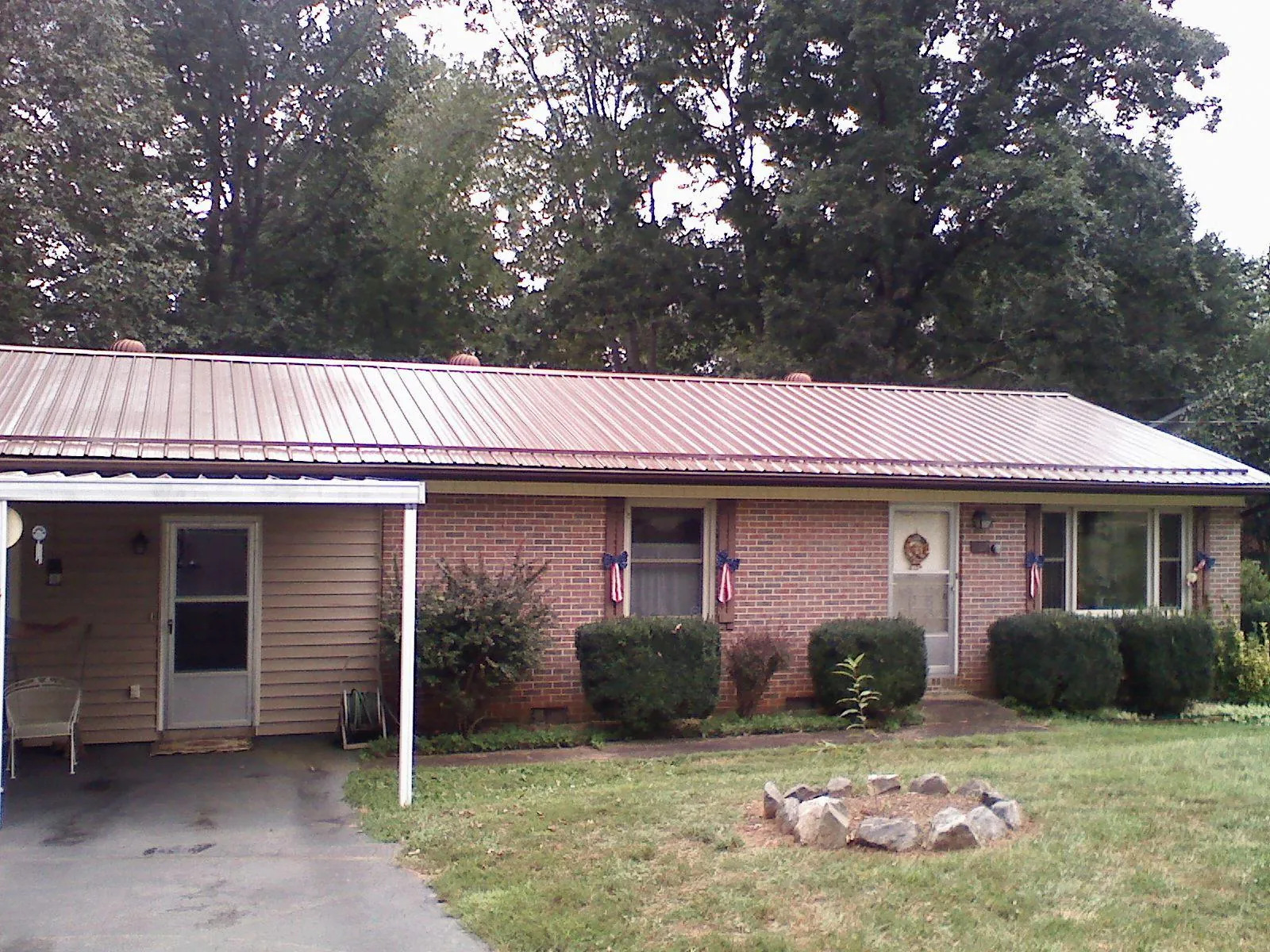 Bronze metal roof and carport on a brick ranch home — Roof Repair work by our crew in Pine Grove